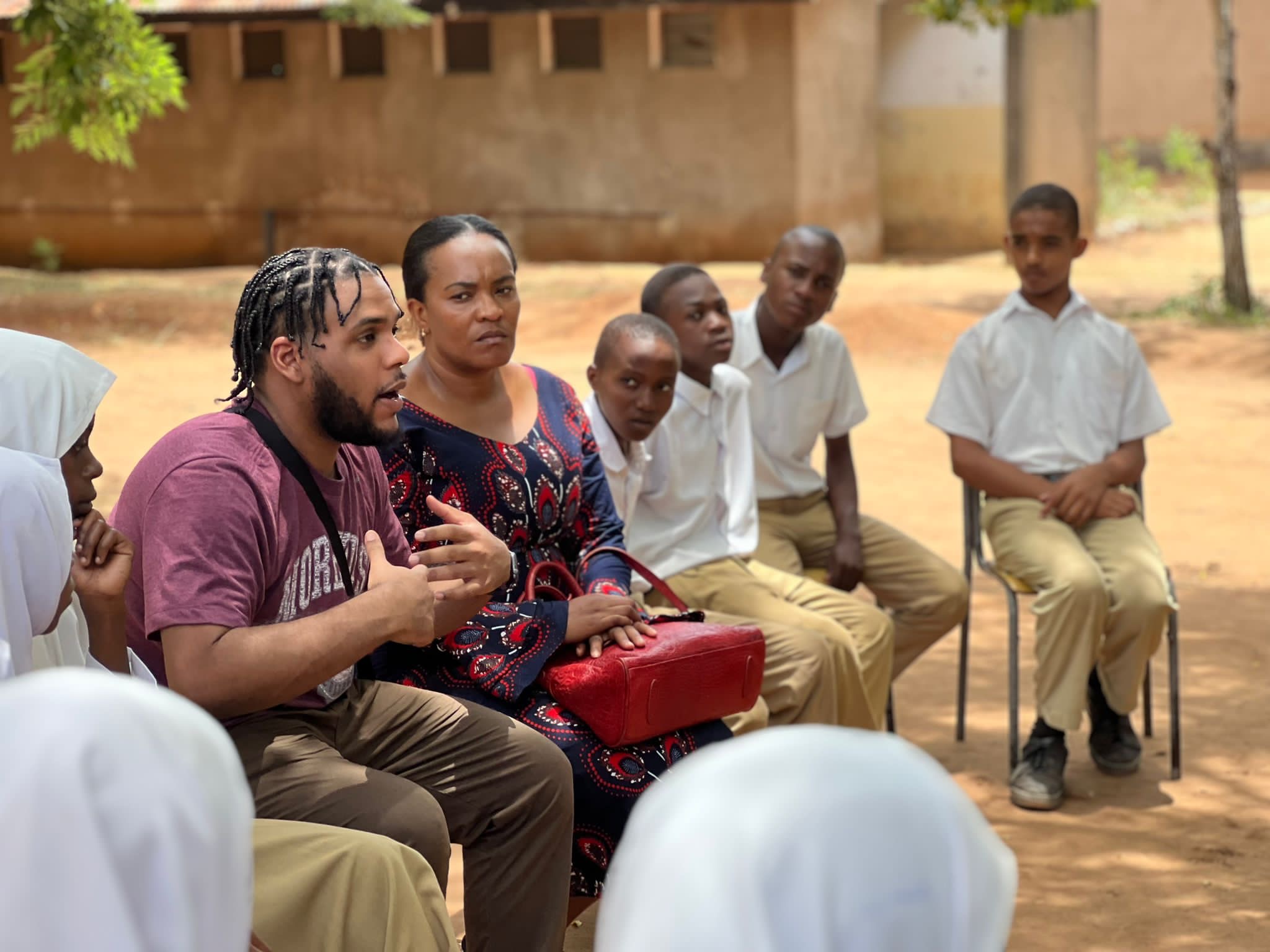 PASI participant speaking with students during a service-learning visit